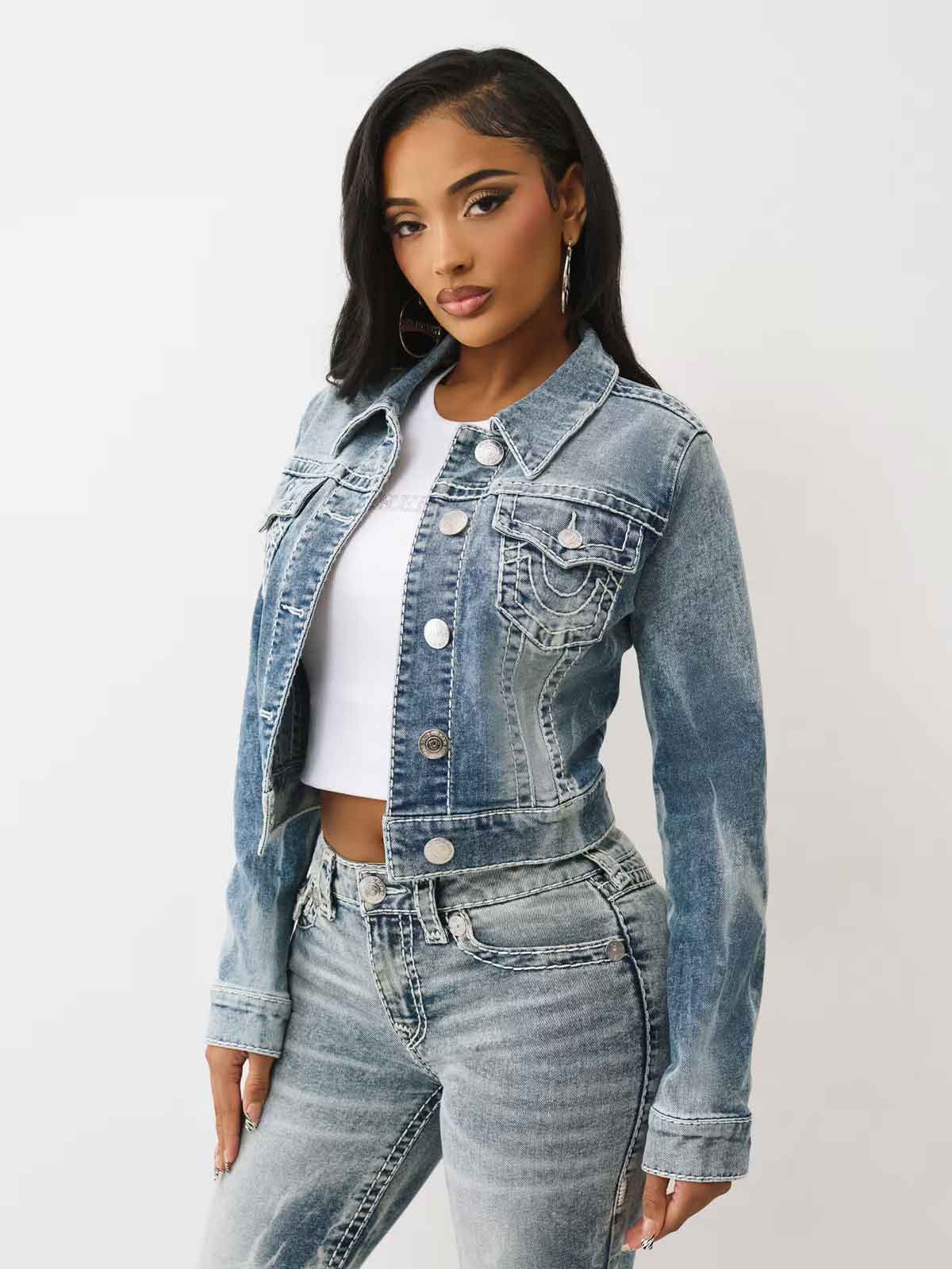 Woman wears true religion jeans with pink stitching