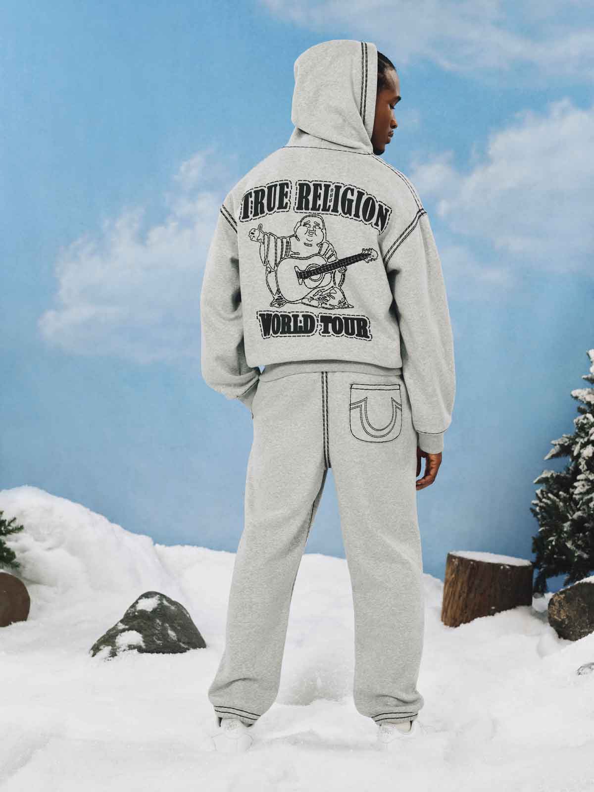 Man wears gray true religion sweat set with black stitching details