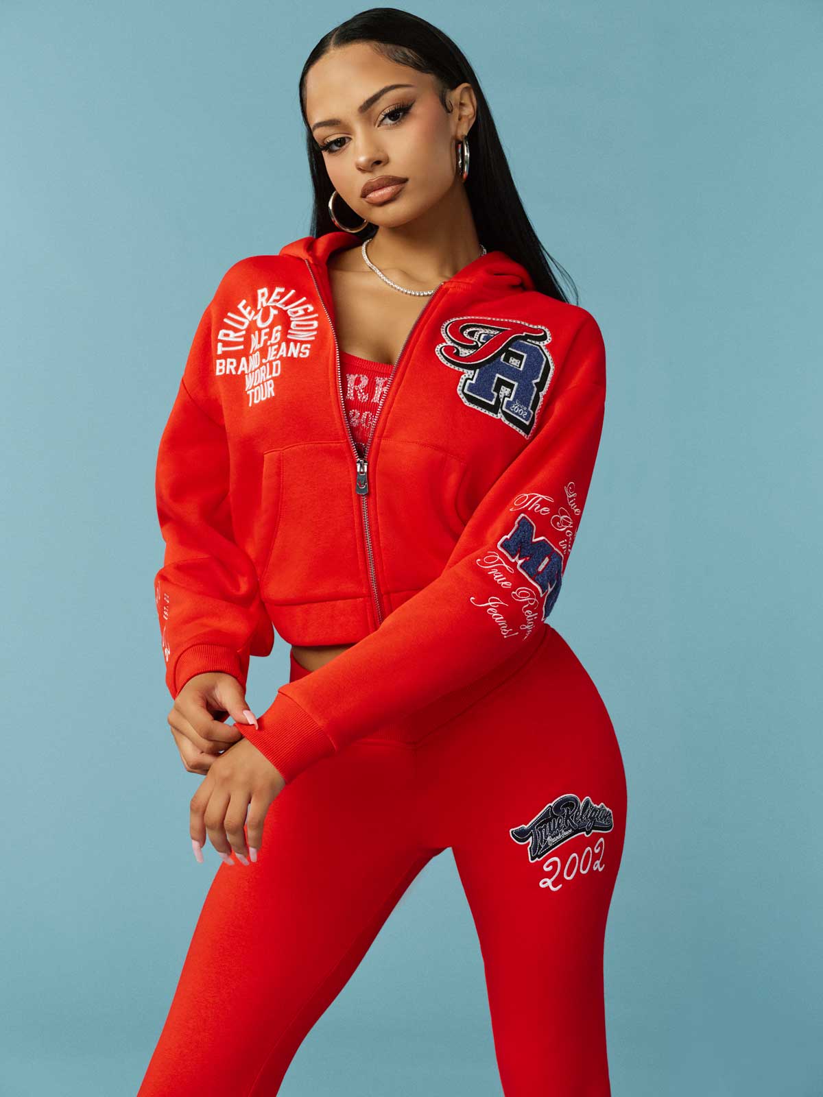 Woman wears true religion red sweat set with white and blue patch detailing